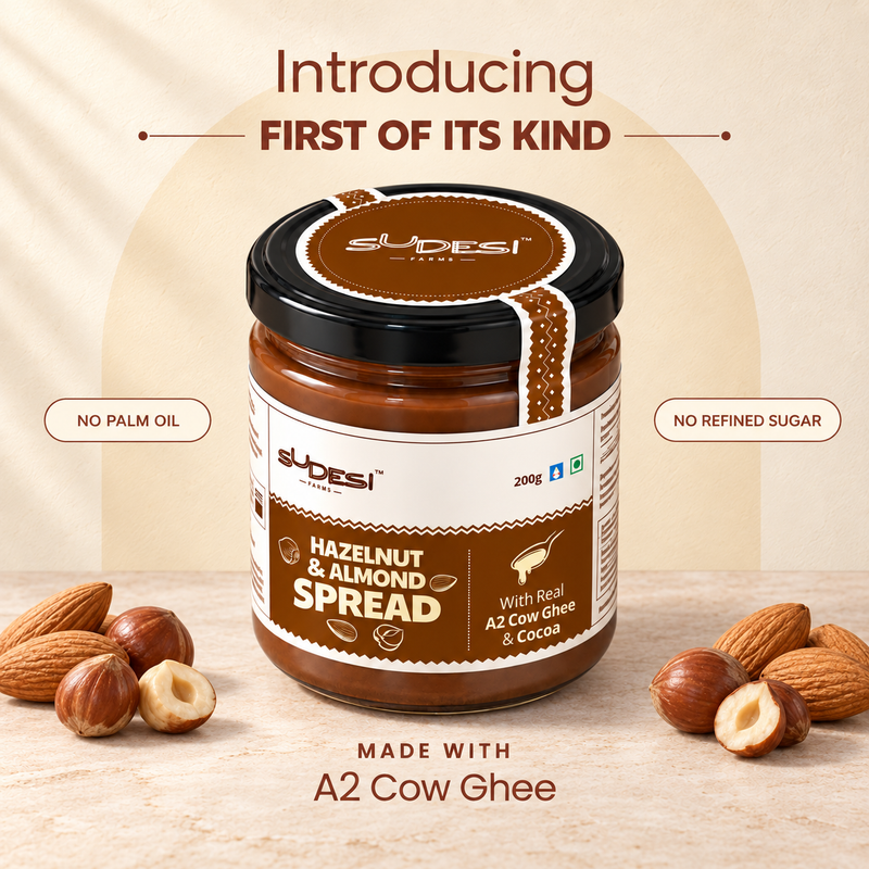 A jar of Sudesi Hazelnut & Almond Spread centered on a beige background with almonds and hazelnuts placed around it. Text above reads 'Introducing First of Its Kind' and text below reads 'Made with A2 Cow Ghee.